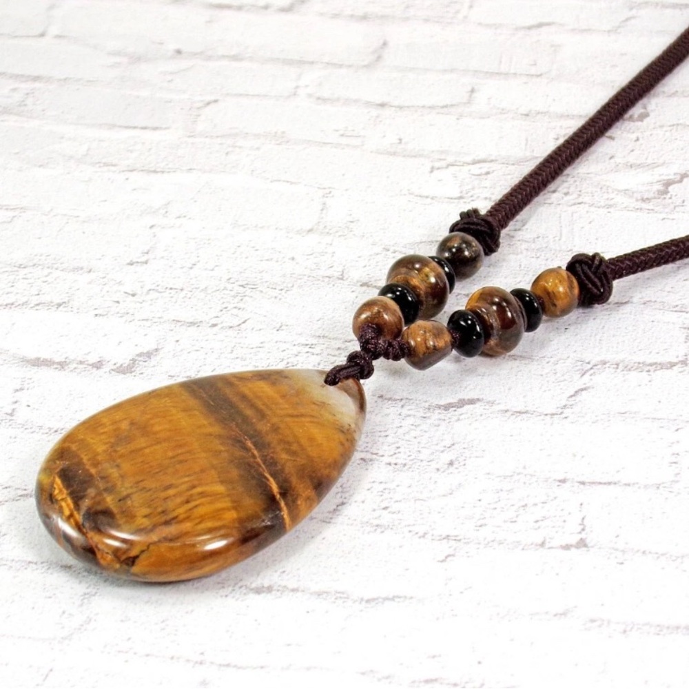 Brown tiger eye stone pendant necklace in a teardrop shape on brown cord